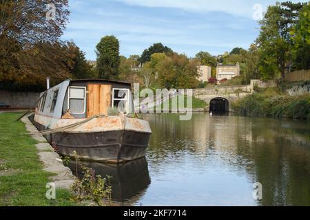 Narrow Boat, Canal Boat, House Boat vertäut neben dem Towpath auf dem Kennet und Avon Kanal mit Einem Tunnel und Hufeisen Walk Brücke im Hintergrund, Stockfoto