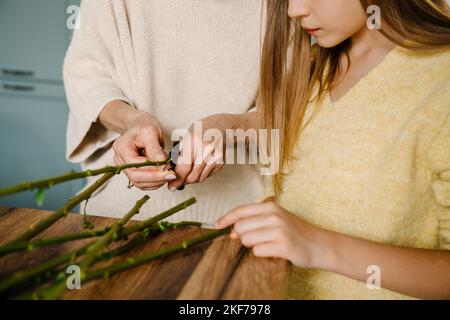 Weiße ältere Frau, die mit ihrer Enkelin zu Hause in der Küche einen Strauß macht Stockfoto