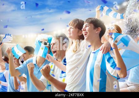 Argentinischer Fußballfan im Stadion. Argentinische Fans auf dem Fußballplatz beobachten das Mannschaftsspiel. Eine Gruppe von Unterstützern mit Flagge und Nationaltrikot Stockfoto