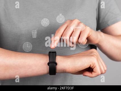 Fitness-Armband an der Hand, Handgelenk der Frau Nahaufnahme. Überprüfen und Steuern von Aktivität, Zustand und Puls. Hochwertige Fotos Stockfoto