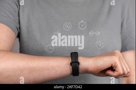 Fitness-Armband an der Hand, Handgelenk der weiblichen Sportlerin Nahaufnahme. Aktivität prüfen, Funktionen auf Smart Band, Tracker. Hochwertige Fotos Stockfoto