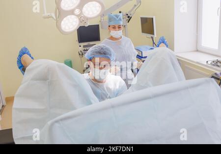 Ein Proktologe und eine Krankenschwester führen eine Operation im Operationssaal durch. Stockfoto