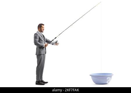 Geschäftsmann mit Angelrute, der in einer auf weißem Hintergrund isolierten Waschschüssel fischt Stockfoto