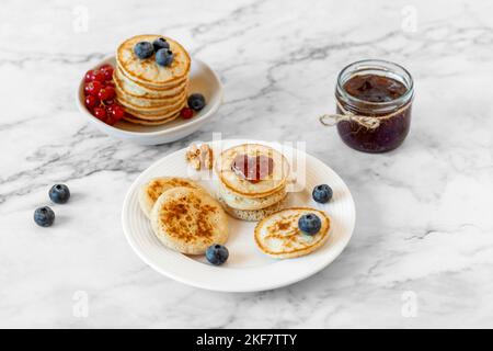 Kleine Pfannkuchen mit herzförmiger Marmelade und frischen Beeren verziert, Valentinstag Idee Stockfoto