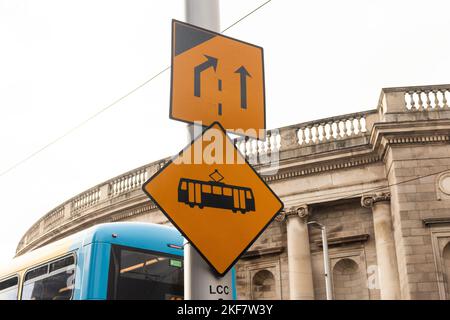 Gelbes Verkehrsschild Verengung der Straße, rechts abbiegen, geradeaus, Straßenbahn in dublin, irland Stockfoto