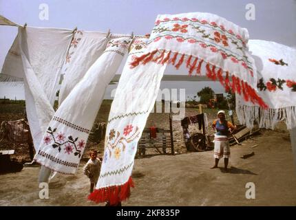 Rumänien, ca. 1990. Lebensstil einer verarmten Familie. Handgenähte Handtücher trocknen im Hof aus. Stockfoto