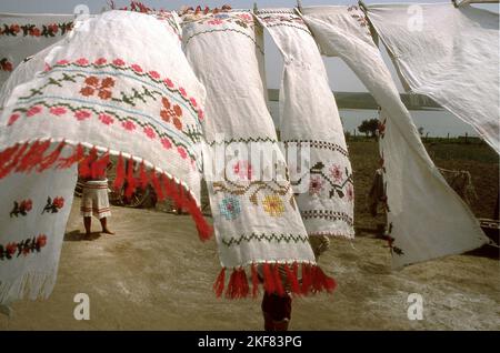 Rumänien, ca. 1990. Lebensstil einer verarmten Familie. Handgenähte Handtücher trocknen im Hof aus. Stockfoto