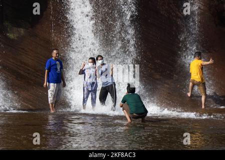 Eine Gruppe von Menschen, die Spaß haben und Masken tragen, während sie in einem Wasserfallpool in Thailand sind. Stockfoto