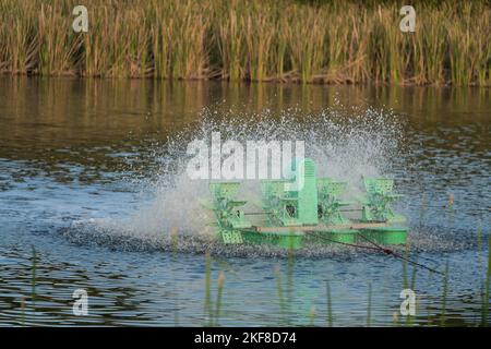 Wasseraufbereitungskonzept. Das Rad der Belüftungsturbine füllt Sauerstoff ins Wasser, die hohe Verschlusszeit erfasst mehrere Wasserspritzer, wählt den Fokus mit flacher Tiefe Stockfoto