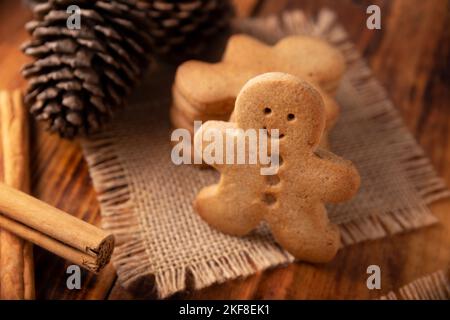 Hausgemachte Lebkuchenkekse für Männer und sternförmige Kekse auf rostischem Holztisch, traditionell zu Weihnachten und an Feiertagen hergestellt. Stockfoto