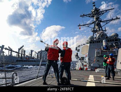 PHILIPPINISCHES MEER (Nov 11, 2022) Gunners Mate 3. Class Parker Covert aus Port Washington, Wisconsin, feuert eine Schusslinie vom Arleigh Burke-class guided-rakete Destroyer USS Benfold (DDG 65) zum Henry J. Kaiser-class Fleet Replenishment Oiler USNS Rappahannock (T-AO 204) während einer Auffüllung auf See in der philippinischen See, November 11. Benfold wird in den USA 7.-Flottenbereich eingesetzt, um einen freien und offenen Indo-Pazifik-Raum zu unterstützen. (USA Navy Foto von Mass Communication Specialist 2. Class Arthur Rosen) Stockfoto