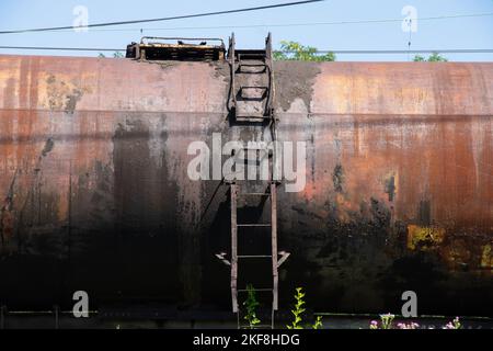 Auf der Eisenbahn steht ein alter stillgelegter Tank für den Öltransport Stockfoto