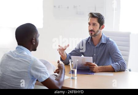 Was würden Sie sagen, ist Ihre größte Stärke. Ein Geschäftsmann interviewing einen Bewerber in einem Büro. Stockfoto