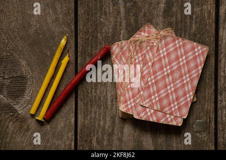 Wahrsagekarten und Kirchenkerzen auf einem alten Holztisch, Wahrsagekarten auf Zauberkarten Stockfoto