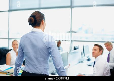 Besprechung mit dem Team. Weibliche Führungskraft diskutiert mit ihrem Team in einem Büro. Stockfoto