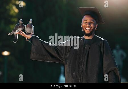 Studentenportrait, Absolvent und Taube mit einem Lächeln, Hut und Mantel für Abschlussfeier, Feier und Leistung im Freien im Park. Universität, Hochschule oder Stockfoto