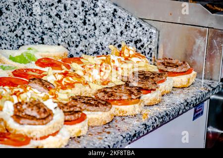 Babaarroudj Burgers in Dely Ibrahim. Cheeseburger Küche Restaurantzubereitung. Offene Hamburger mit pommes Frites, Steaks, Salat und Tomaten. Stockfoto