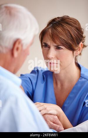 Sie kümmert sich wirklich um ihre Patienten. Eine Krankenschwester überprüft ihre ältere Patientin. Stockfoto