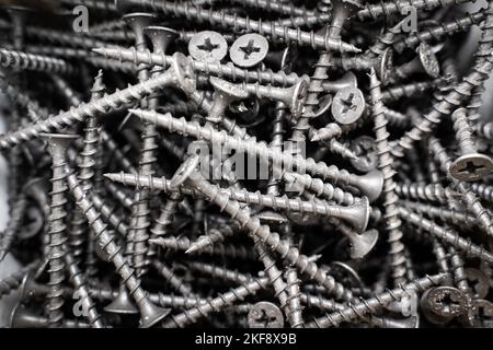 Schwarze lange selbstschneidende Schrauben in Nahaufnahme in einer Box. Holzschrauben Stockfoto