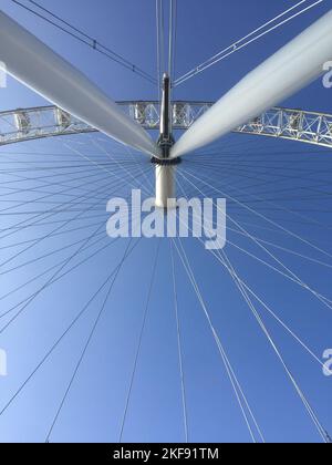 Eine Aufnahme des London Eye in einem niedrigen Winkel vor einem blauen Himmel Stockfoto
