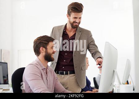 Spielen mit verschiedenen Designs. Zwei Designer arbeiten zusammen an einem Computer. Stockfoto