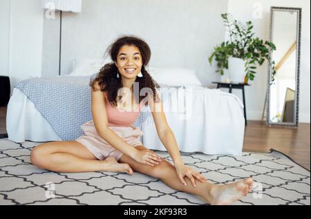 Nette afrikanische Frau, die morgens zu Hause Yoga macht. Gesunder Lebensstil und Achtsamkeitskonzept Stockfoto