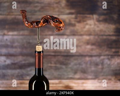 Flasche Wein mit altem Vintage-Korkenzieher aus Holz auf Holzhintergrund mit Kopierraum Stockfoto