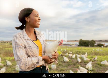 Schwarze Frau, Hühnerfarm und glücklich mit kleinen Unternehmen, Wachstum und landwirtschaftliche Entwicklung im Freien in der Natur. Landwirt, Tier und Nachhaltigkeit Stockfoto
