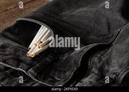 Zigaretten in einer Tasche in grauen Jeans, Zigarettensucht und Mode, Rauchen Stockfoto