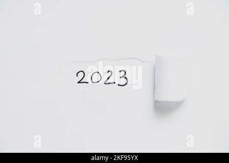 2023 geschrieben auf weißem zerrissenem Papier, glückliches neues Jahr 2023 Stockfoto