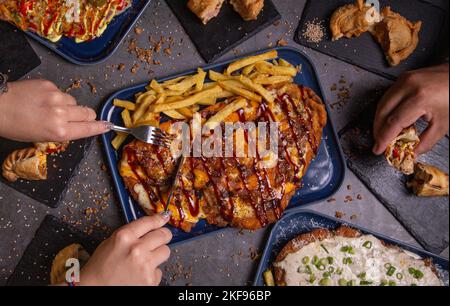 Flache Barmahlzeiten mit Empanadas und Händen. Stockfoto