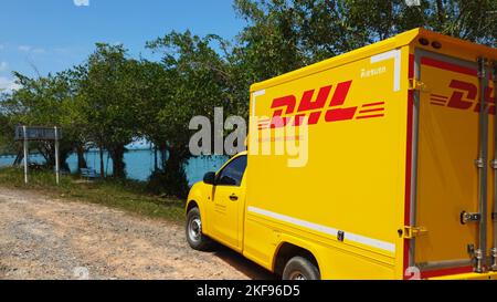 KOH CHANG, TRAT, THAILAND – 11. NOVEMBER 2022: DHL-LIEFERWAGEN. DHL ist weltweit Marktführer in der Logistikbranche. Das Auto ist am Strand. Der Fahrer ruht sich an sonnigen Tagen auf einer tropischen exotischen Insel aus Stockfoto