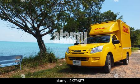 KOH CHANG, TRAT, THAILAND – 11. NOVEMBER 2022: DHL-LIEFERWAGEN. DHL ist weltweit Marktführer in der Logistikbranche. Das Auto ist am Strand. Der Fahrer ruht sich an sonnigen Tagen auf einer tropischen exotischen Insel aus Stockfoto