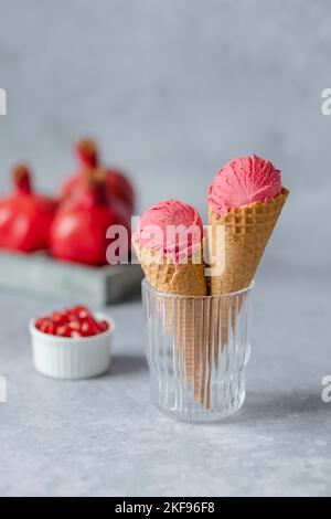 Zwei Schaufeln cremiger Granatapfel-Eis-Kegel. Gesunde vegane Desserts. Stockfoto