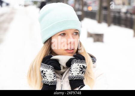 Mädchen im Winter im Winter Kleidung in der Stadt für einen Spaziergang, Porträt eines Mädchens auf der Straße im Winter Stockfoto