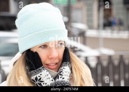 Mädchen im Winter im Winter Kleidung in der Stadt für einen Spaziergang, Porträt eines Mädchens auf der Straße im Winter Stockfoto