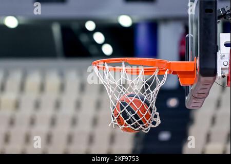 Basketball, der in einem Basketballfeld mit leeren Sitzen ins Netz geht Stockfoto