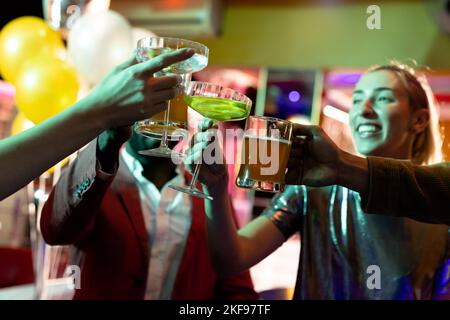 Glückliche Gruppe von männlichen und weiblichen Freunden, die in einem Nachtclub trinken Stockfoto