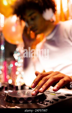 Vertikales Bild eines afroamerikanischen djs, der Musik in einem Nachtclub spielt, selektiver Fokus Stockfoto