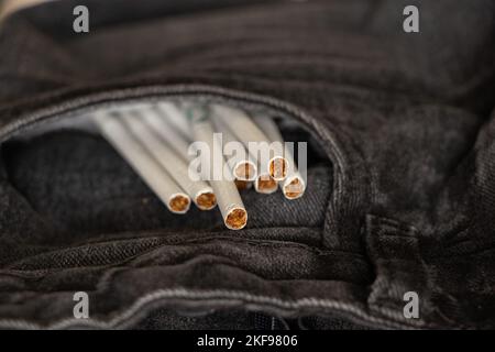 Zigaretten in einer Tasche in grauen Jeans, Zigarettensucht und Mode, Rauchen Stockfoto