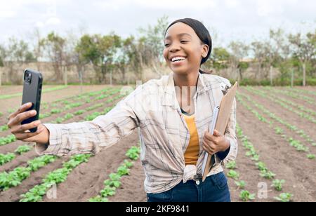 Schwarze Frau, Farm und Landwirtschaft Selfie mit Landwirt in Erntefeld für Landwirtschaft und Nachhaltigkeit im Freien. Lächeln im Bild, Smartphone und Stockfoto