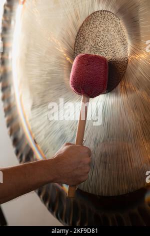 Mann, Der Während Der Spirituellen Praxis Aufgehängte Gong-Übungen Spielt Stockfoto