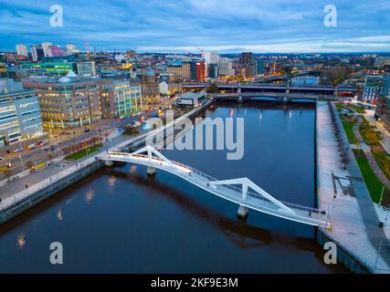 Luftaufnahme von der Drohne in der Dämmerung der Skyline von Glasgow und der Squiggly Bridge über den Fluss Clyde, Schottland, Großbritannien Stockfoto