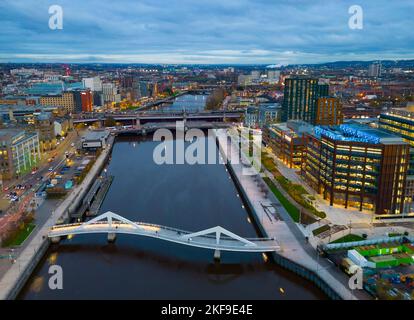 Luftaufnahme von der Drohne in der Dämmerung der Skyline von Glasgow und der Squiggly Bridge über den Fluss Clyde, Schottland, Großbritannien Stockfoto