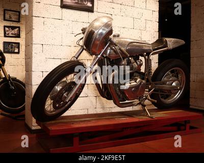 Ein restauriertes altes Retro-Motorrad, das in einem Café ausgestellt wurde, um Kunden und Enthusiasten anzuziehen. Stockfoto