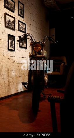 Ein restauriertes altes Retro-Motorrad, das in einem Café ausgestellt wurde, um Kunden und Enthusiasten anzuziehen. Stockfoto