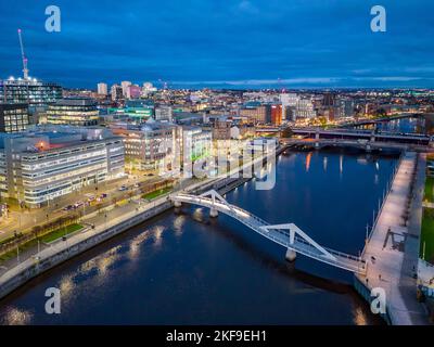 Luftaufnahme von der Drohne in der Dämmerung der Skyline von Glasgow und der Squiggly Bridge über den Fluss Clyde in Broomielaw, Schottland, Großbritannien Stockfoto