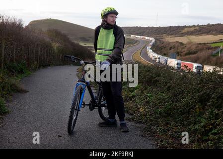 Radfahrer, der den LKW-Verkehr zum Hafen von dover am M20 betrachtet Stockfoto