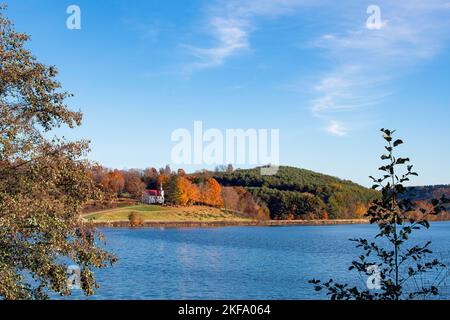 Wunderschöne alte Landkirche auf einem Hügel in Appalachia mit Blick auf einen See mit negativem Platz. Stockfoto