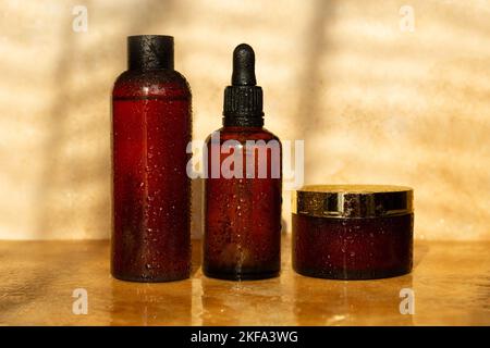 Natürliche Kosmetikgläser. Braune Farbe. Sonnenlicht-Kosmetik. Natürliche Kosmetik, Wassertropfen. Apotheke, Labor, Naturkosmetik. Stockfoto